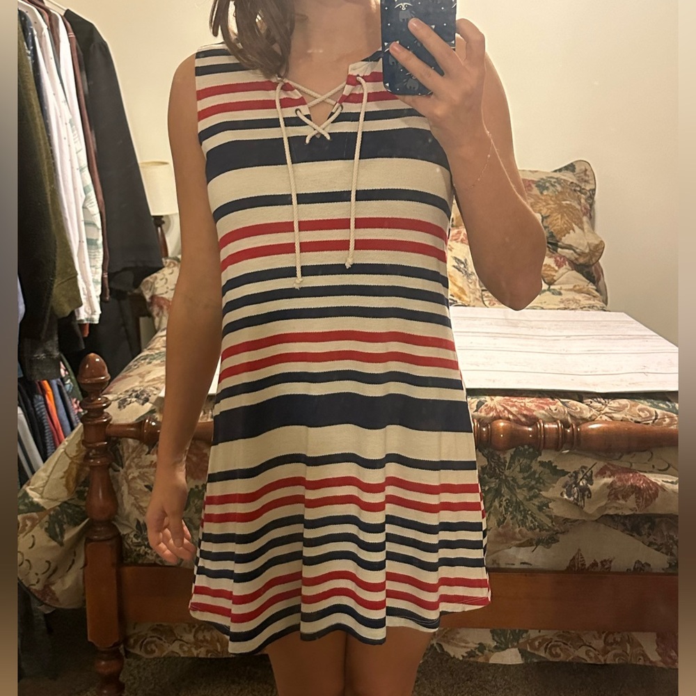 About a girl striped dress with cross string in front; red white and blue